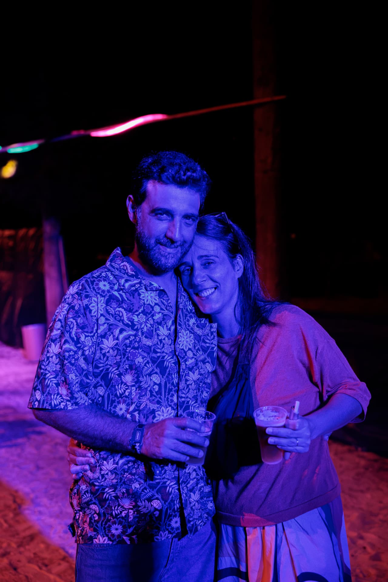 Couple smiling under blue and purple light
