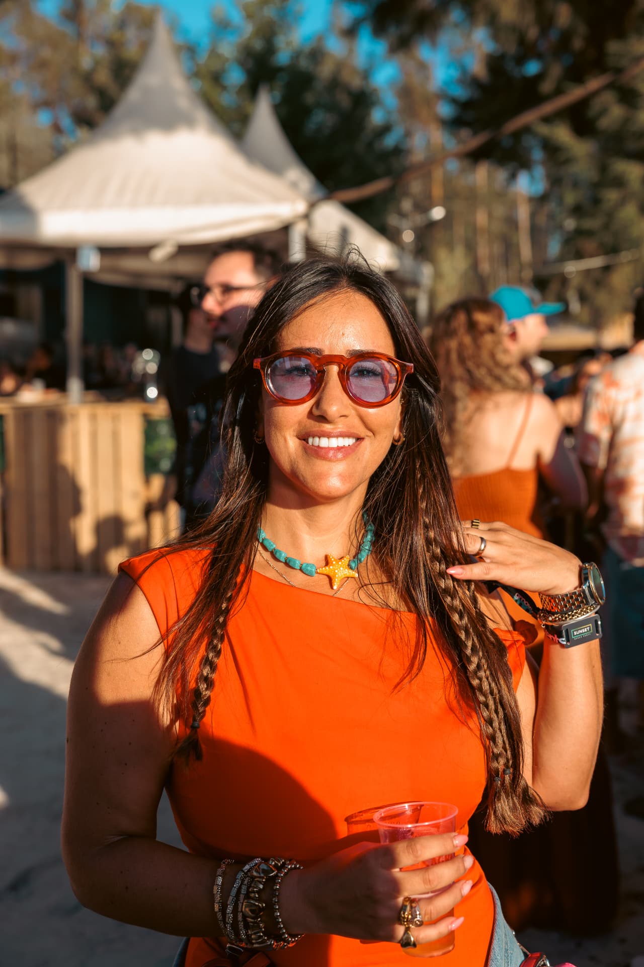 Guest in orange smiling in the sun