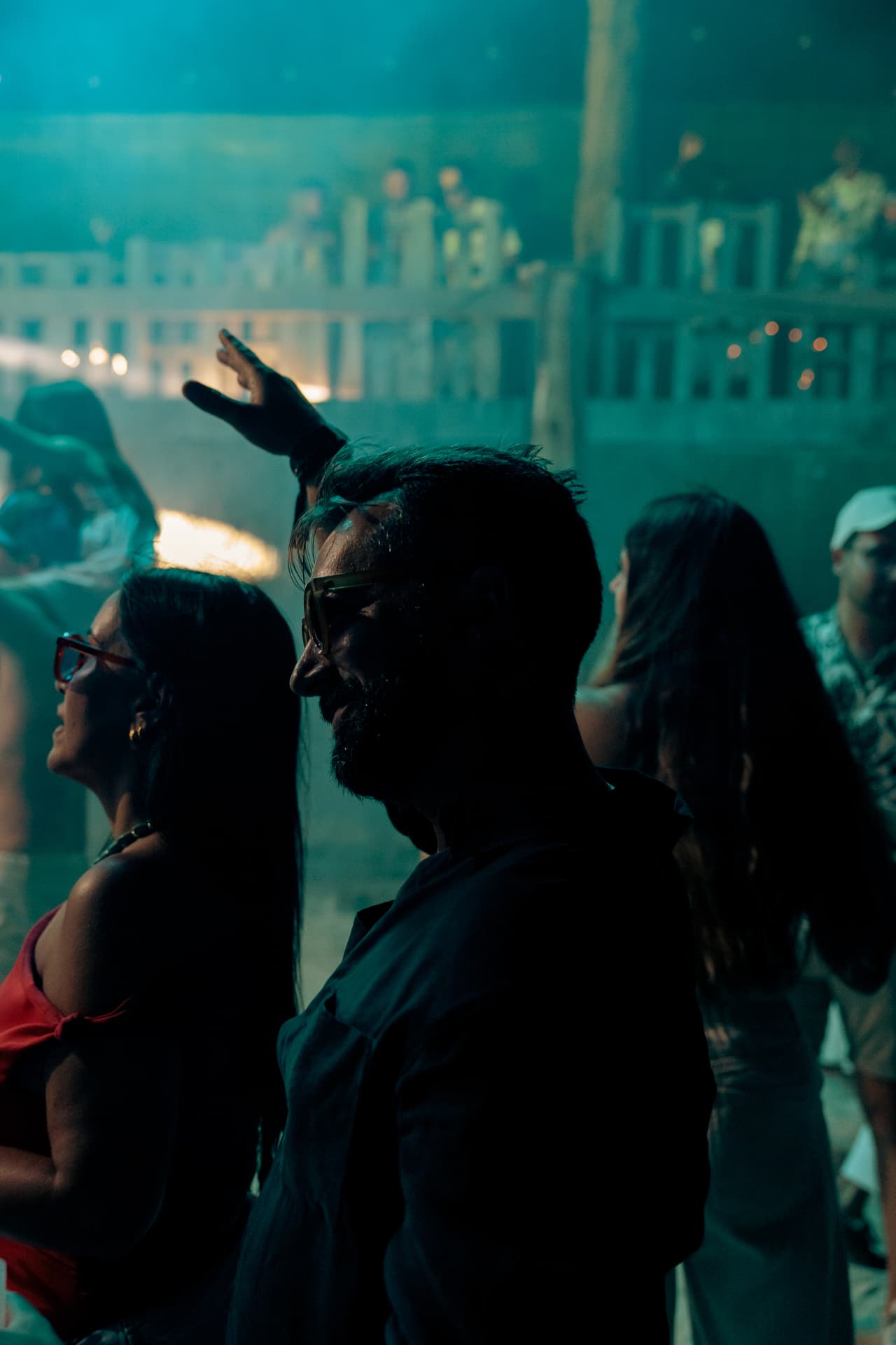 Crowd in teal haze with a hand in the air