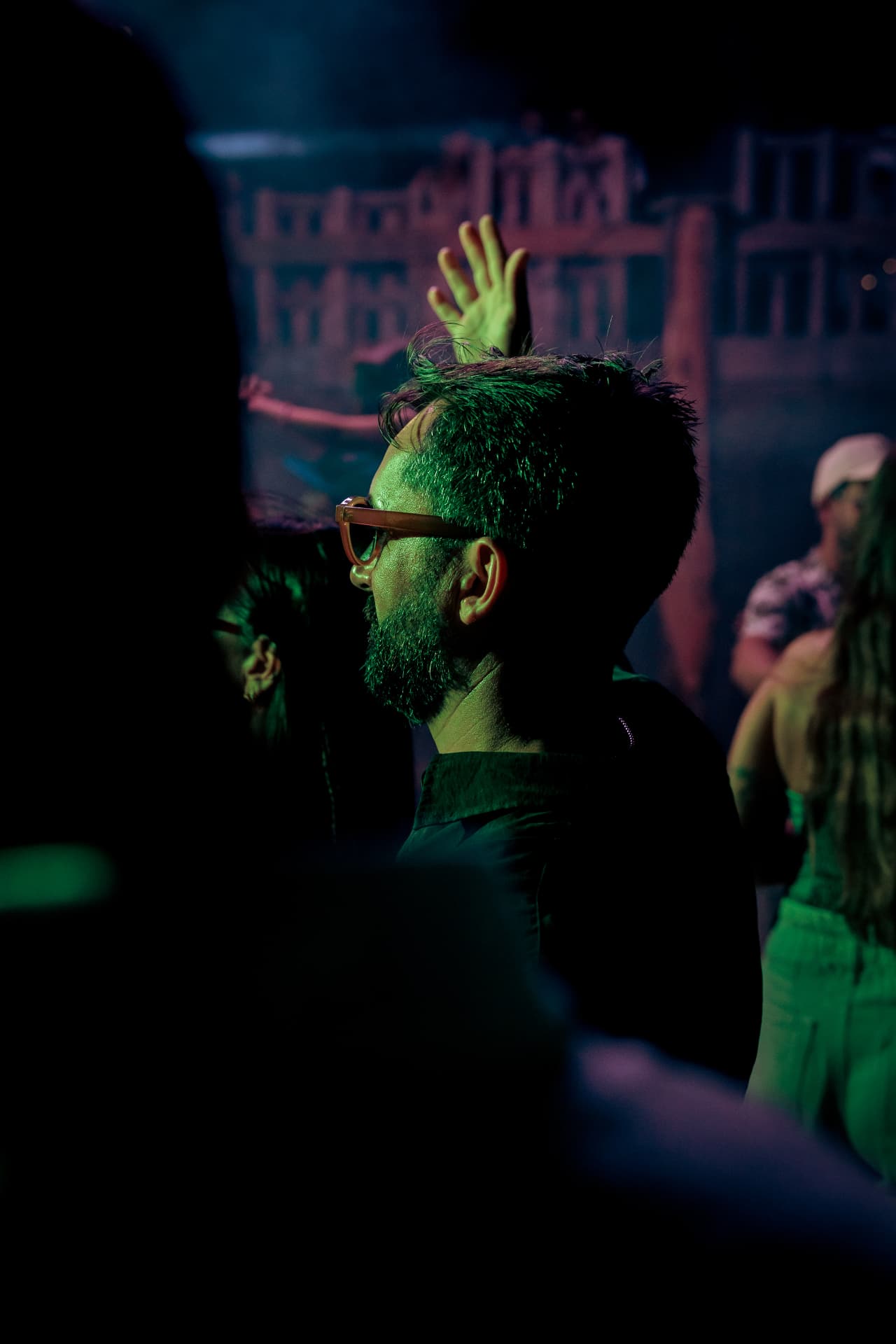 Guest with a raised hand in the blue dark